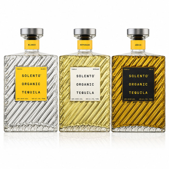 Three Solento Organic Tequila bottles lined up on a white background: Blanco with a yellow label and silver liquid, Reposado with a white label and golden-amber liquid, and Ate de Joven with a black label and darker amber liquid.