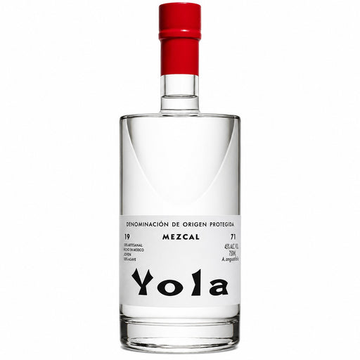 A clear glass bottle of Yola Mezcal with a white label and a bright red cap, set against a plain white background.
