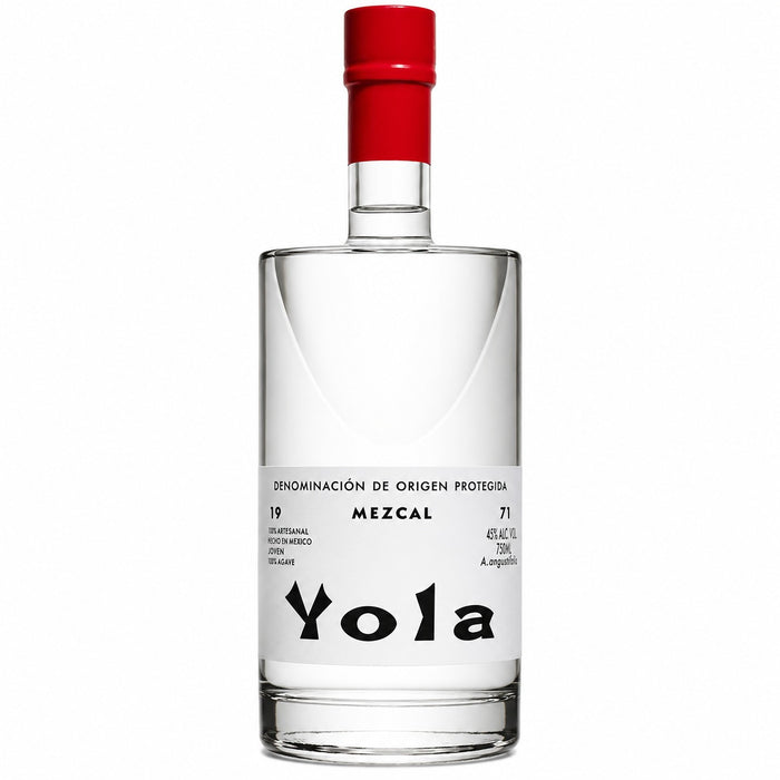 A clear glass bottle of Yola Mezcal with a white label and a bright red cap, set against a plain white background.