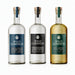 Three Wild Common tequila bottles on a white background: a clear Tequila Blanco bottle with a blue label, a clear Tequila Blanco bottle with a black label, and a golden Tequila Reposado bottle with a green label.