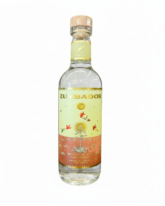 A bottle of Zumbador tequila on a plain white background. The clear glass bottle features a light yellow and orange label with illustrations of birds, a sun, and an agave plant, topped with a cork.